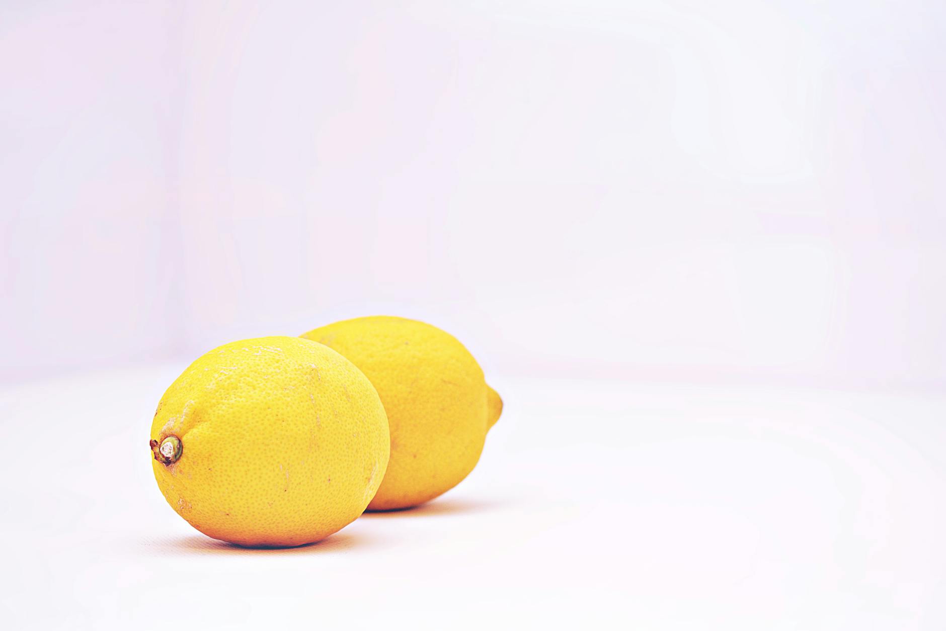 Two vibrant lemons against a white background symbolizing fresh approach to sensation and pleasure