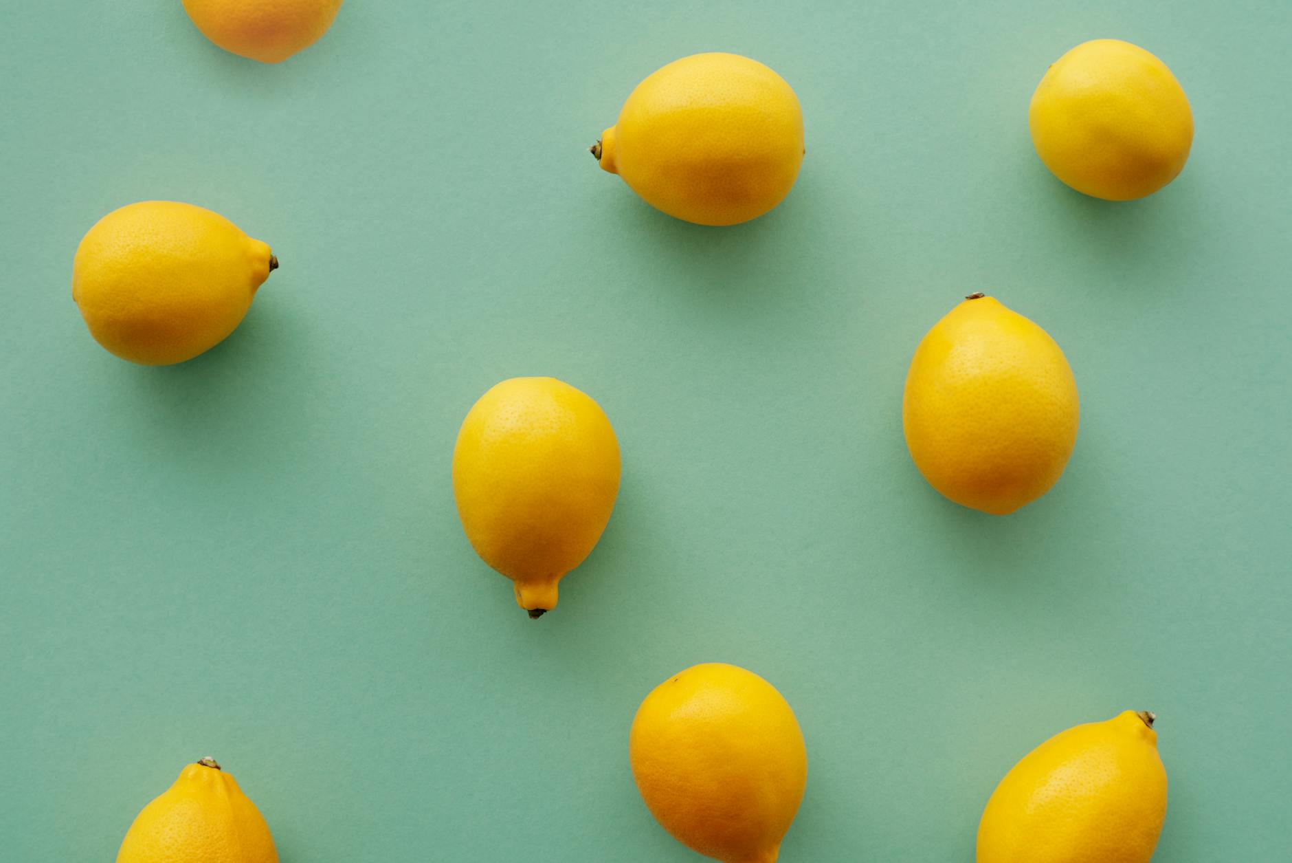 Bright yellow lemons arranged on pastel green background representing fresh exploration and discovery