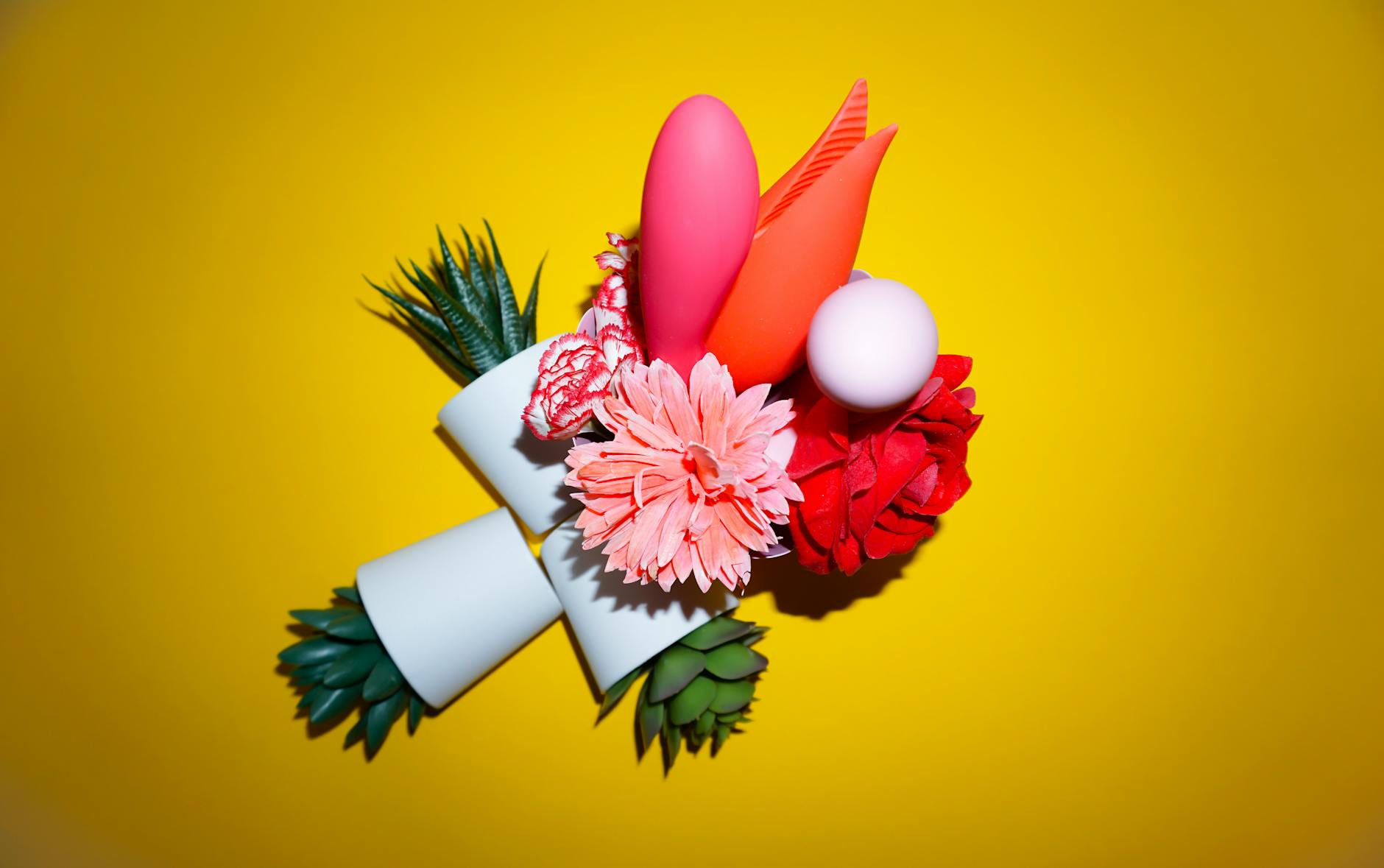 A person holding a basket containing colorful vibrators and a pink flower
