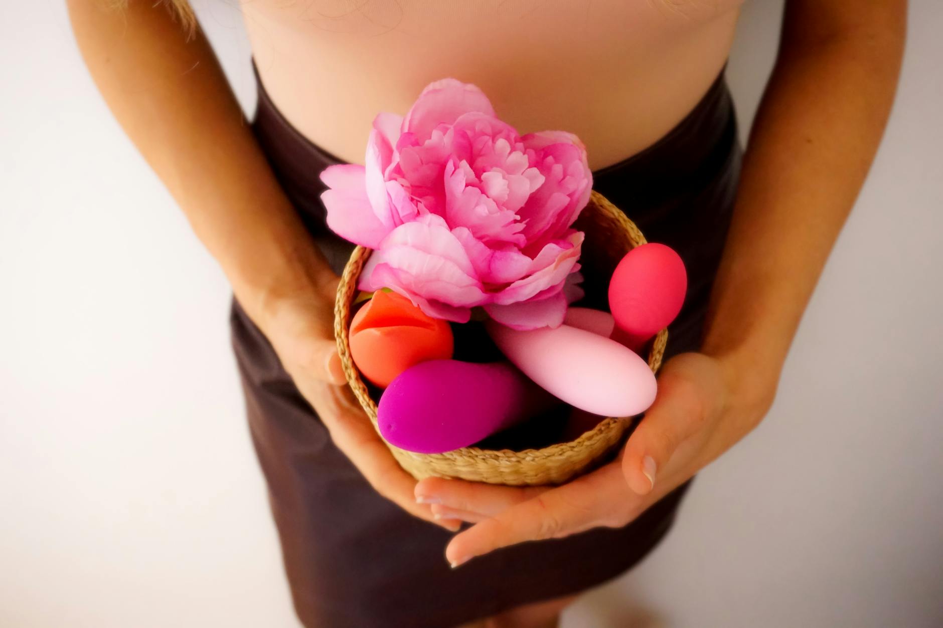 A basket of colorful clitoral vibrators including lemon-shaped toys and a pink flower