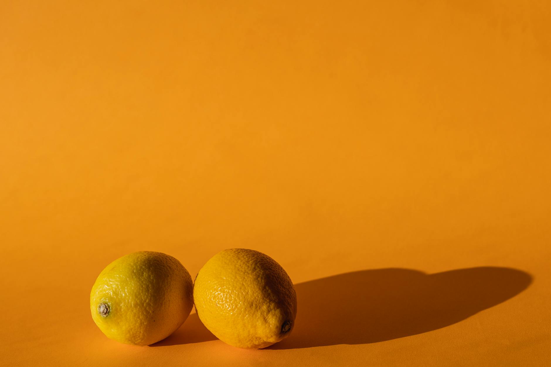 Fresh yellow lemons arranged on a soft pastel green background, symbolizing renewal and gentle brightness after a major life transition